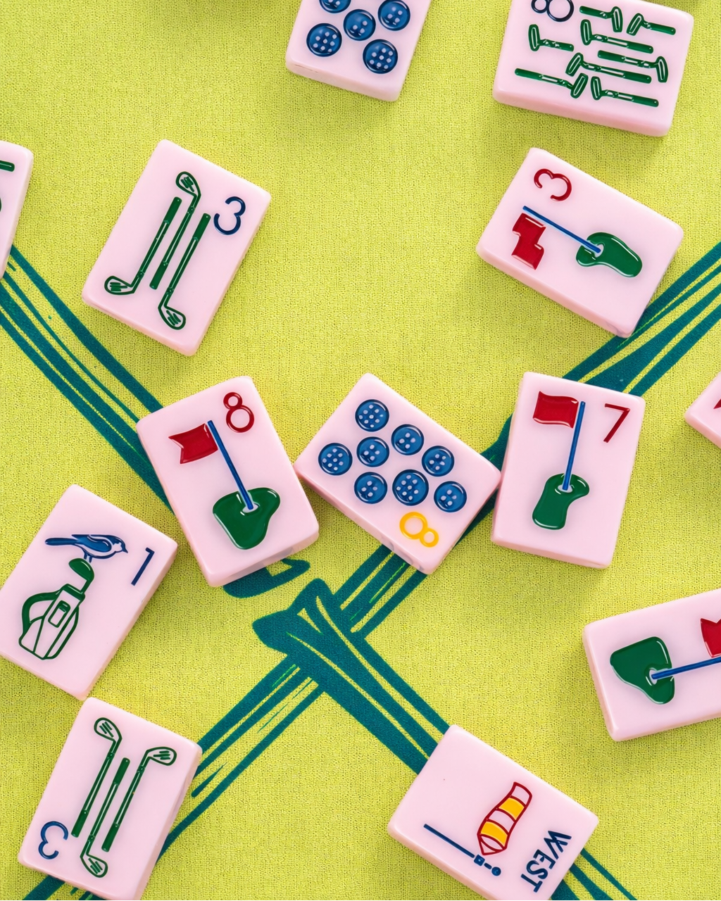 Collection of colorful golf themed Mahjong tiles on a green trellis playing mat